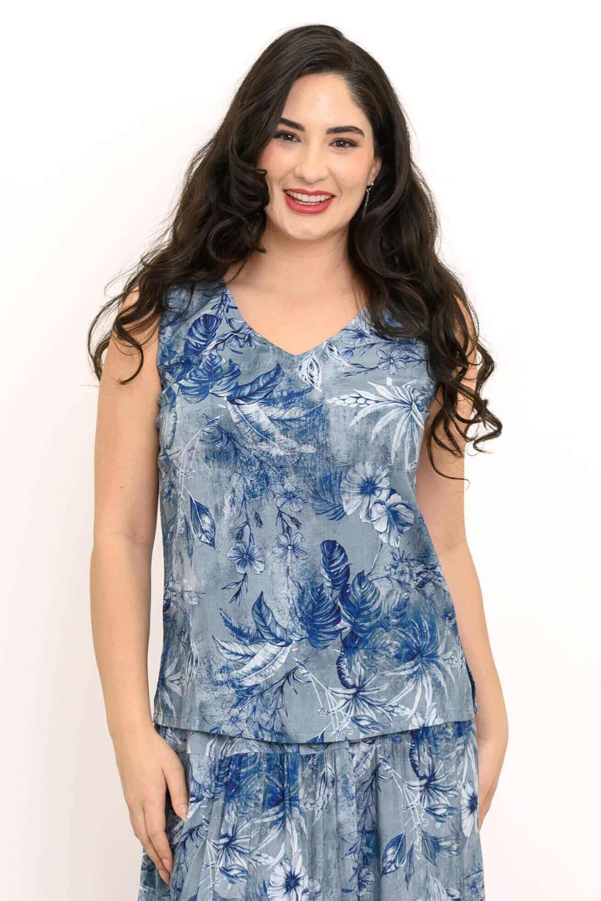 Front view of model wearing a blue floral sleeveless V-neck tank top