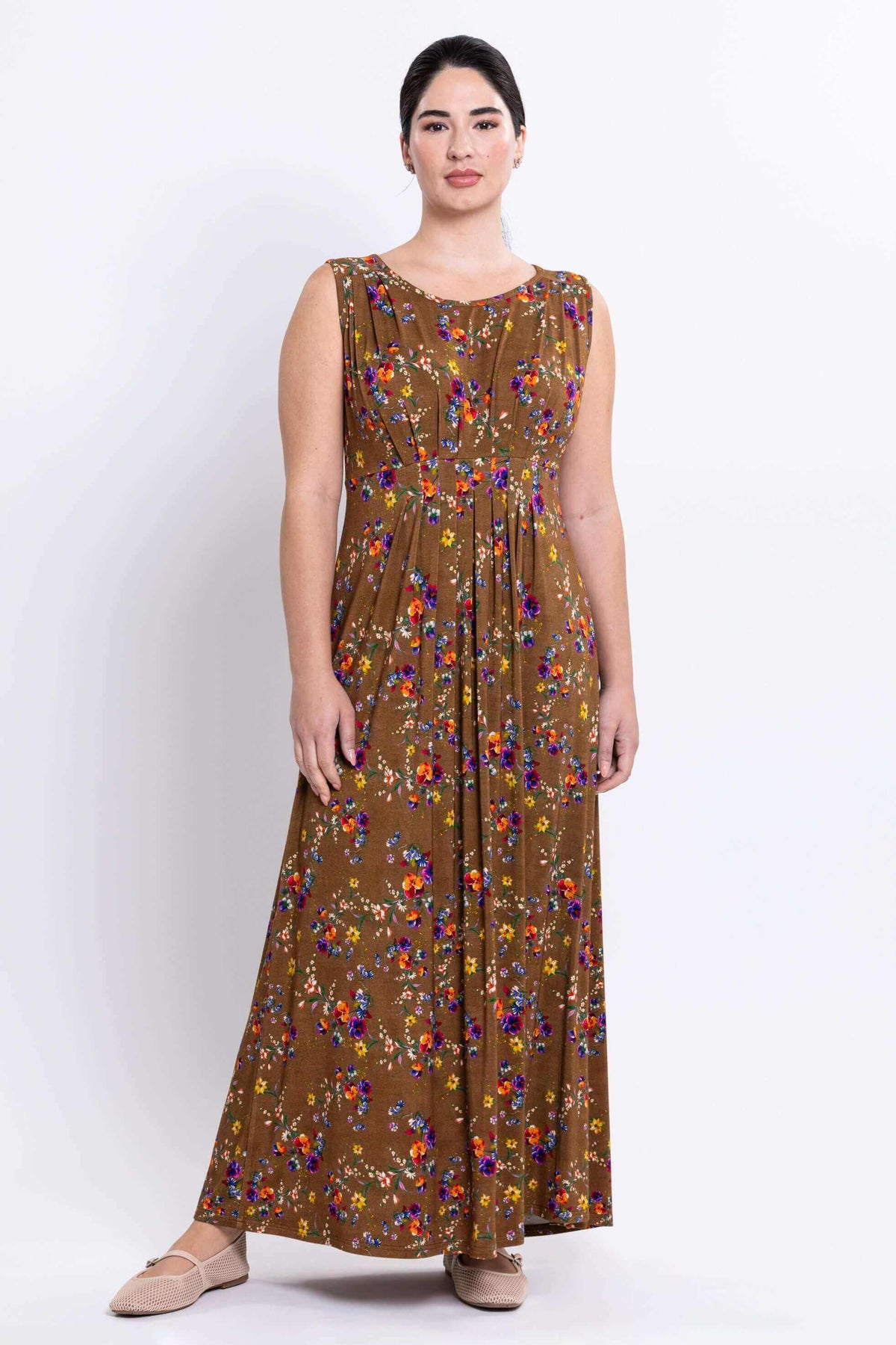 Front view of a model wearing a brown floral sleeveless maxi dress with pleated details