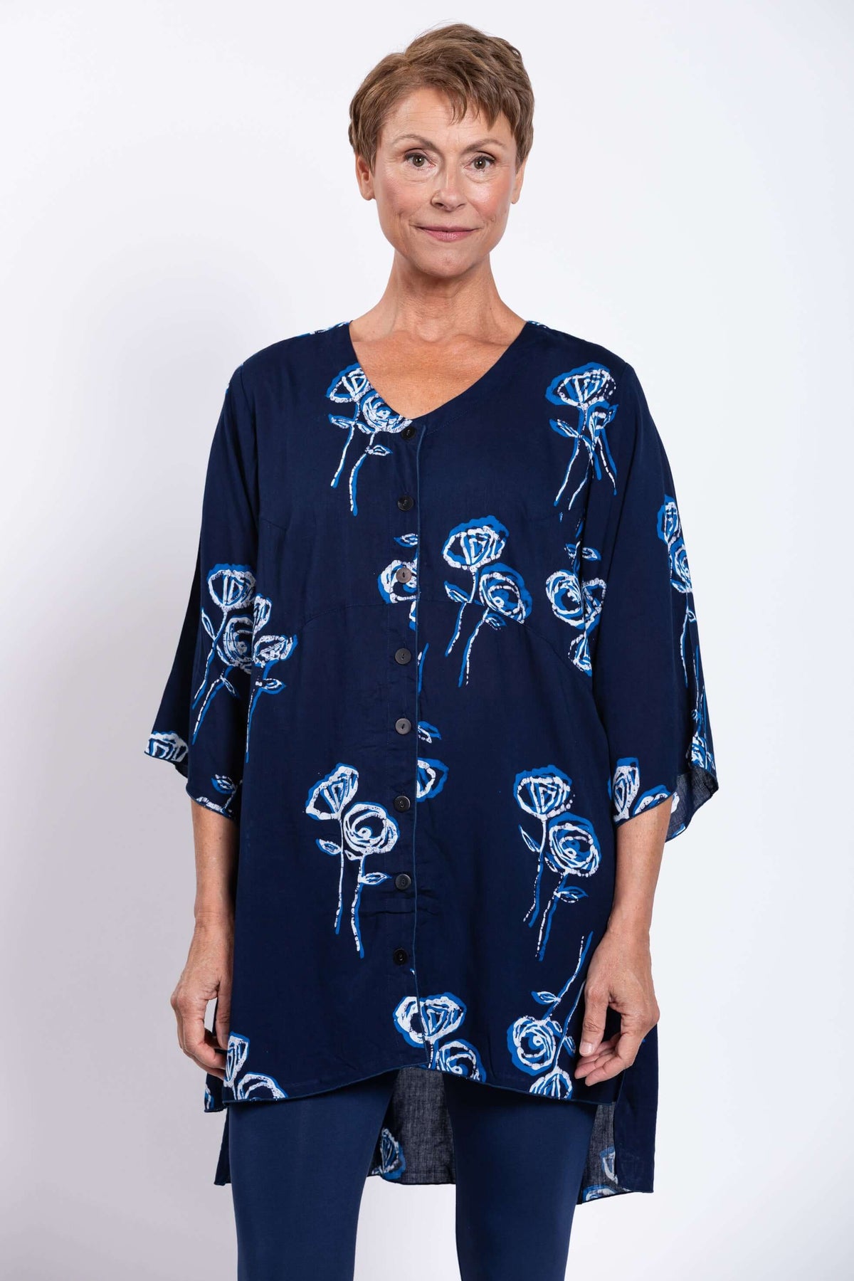 Front view of woman wearing navy blue Darla blouse with blue and white floral design