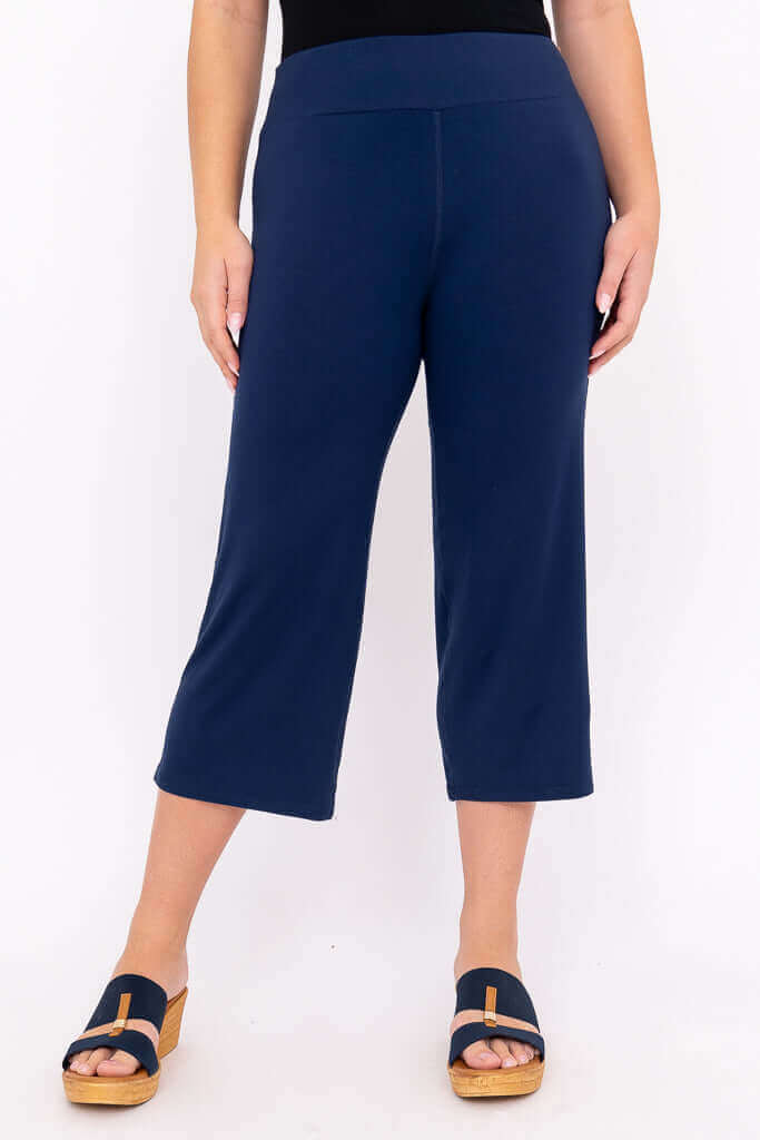 Front view of a model wearing navy blue bamboo yoga capri pants