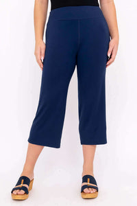 Front view of a model wearing navy blue bamboo yoga capri pants
