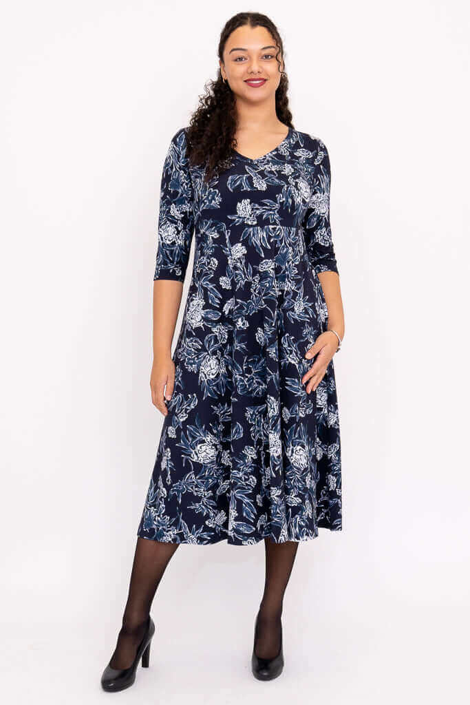 Front view of woman wearing navy floral midi dress with V-neck and 3/4 sleeves