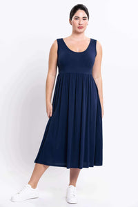 Navy sleeveless midi dress shown from the front on model with white sneakers