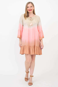 Woman in a peach and pink ombre dress with flounce hem posing front view