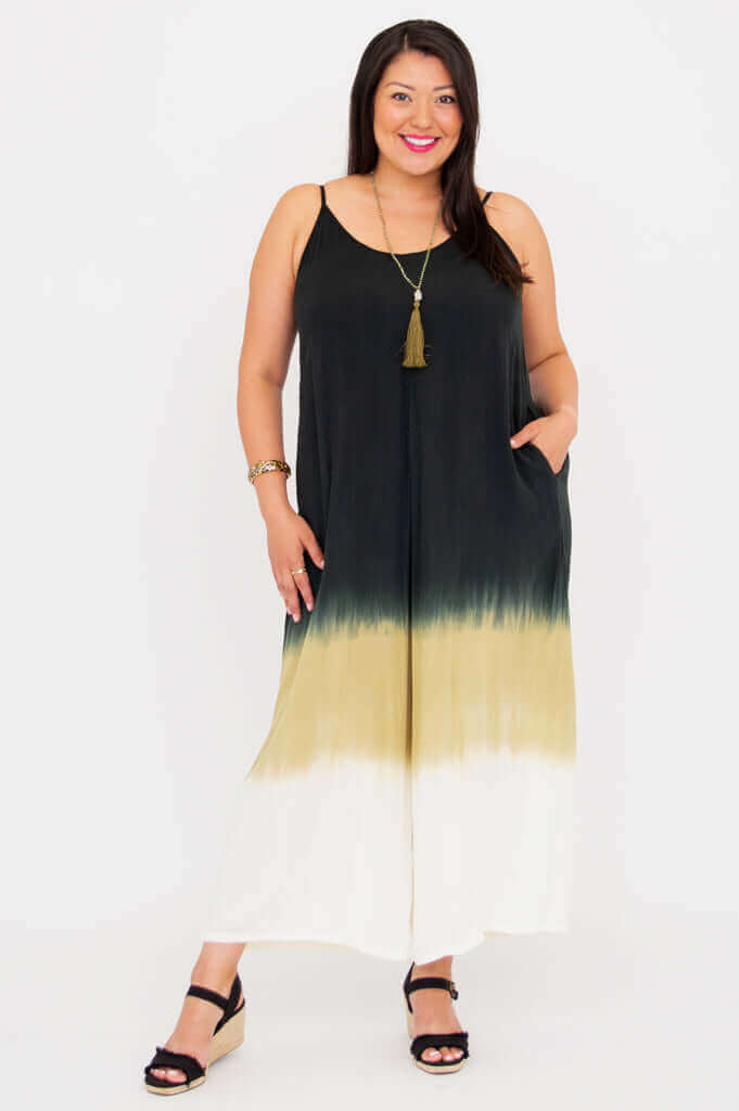 Front view of a woman wearing a sleeveless ombre jumpsuit with spaghetti straps and pockets