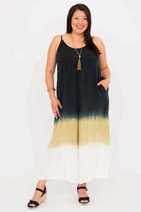 Front view of a woman wearing a sleeveless ombre jumpsuit with spaghetti straps and pockets