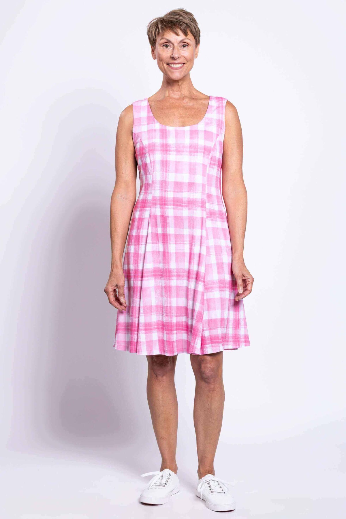 Front view of a woman wearing a pink plaid sleeveless A-line dress with scoop neckline