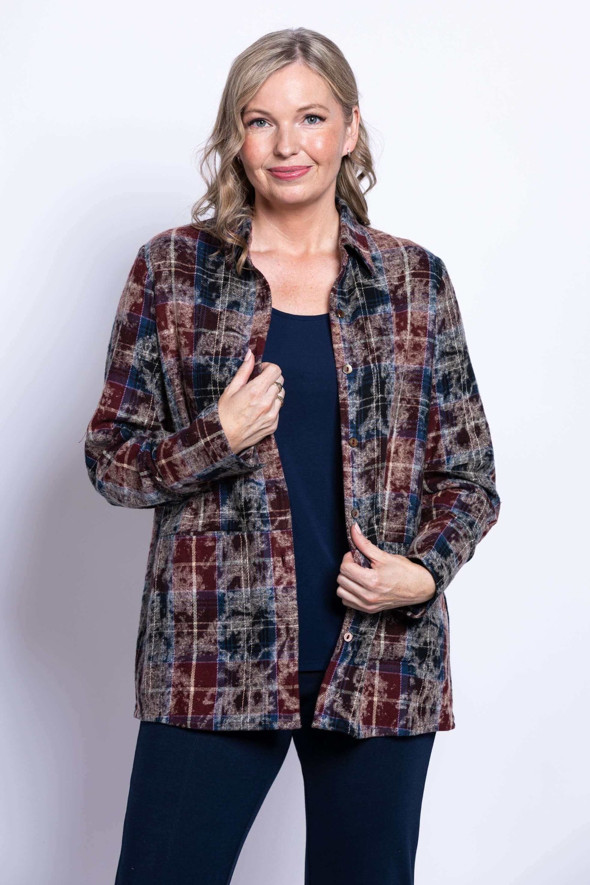 Close up front view of a woman wearing a multi plaid cotton shirt collar jacket over a navy top.