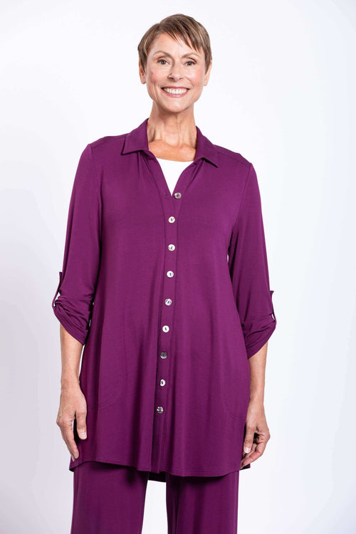 Front view of a woman wearing a long, purple button-up bamboo tunic top