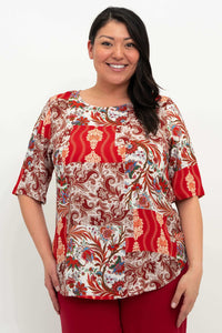Front view of model wearing a red and multicolor patchwork print blouse