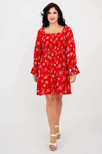 Front view of woman wearing a red ditsy floral dress with long sleeves and square neckline