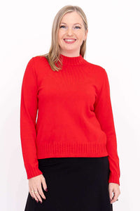 Front view of a woman wearing a red mock neck sweater with cable knit details