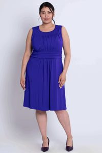 Front view of model in sleeveless royal blue dress with ruched details and waistband