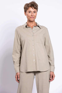 Front view of woman wearing a sage relaxed linen shirt and matching pants