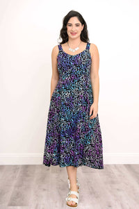 Woman wearing a sleeveless A-line dress with blue and purple swirl pattern, front view