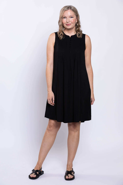 Front view of woman wearing a sleeveless black A-line dress with pintuck details