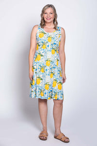 Front view of woman wearing sleeveless dress with lemon tile pattern