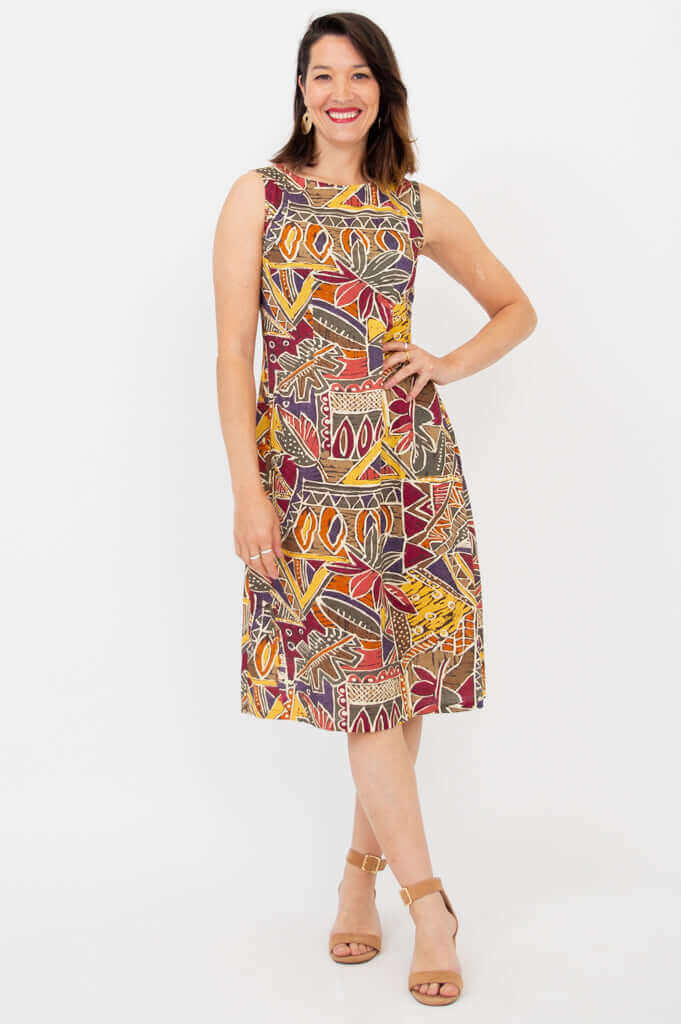 Woman modeling sleeveless tribal print dress, hand on hip, front view