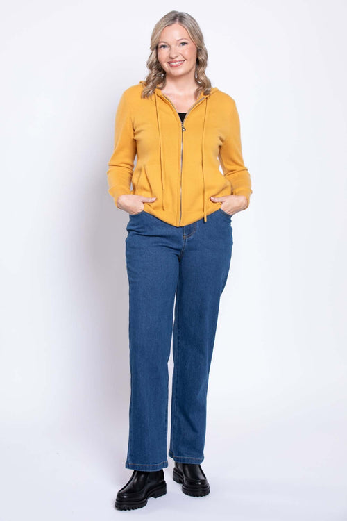 Model wearing straight leg blue jeans and a yellow zip-up hoodie from the front