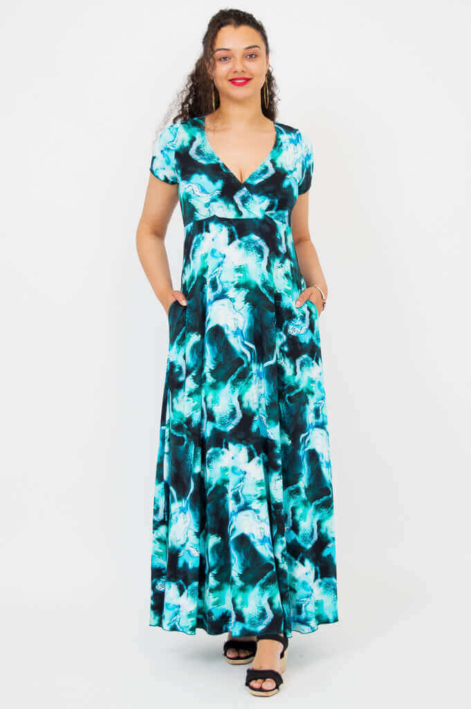 Front view of a woman wearing a teal and black watercolor print bamboo maxi dress with short sleeves