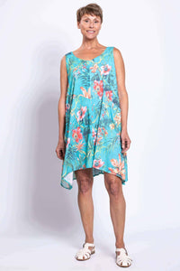 Woman in turquoise floral dress, front view, standing with arms relaxed