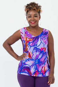 Front view of a woman wearing a vibrant floral V-neck tank top with wide shoulder straps