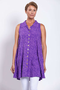 Front view of woman wearing a sleeveless violet A-line button up tank with abstract print
