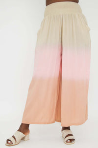 Front view of wide leg ombre pants in peach and beige tones