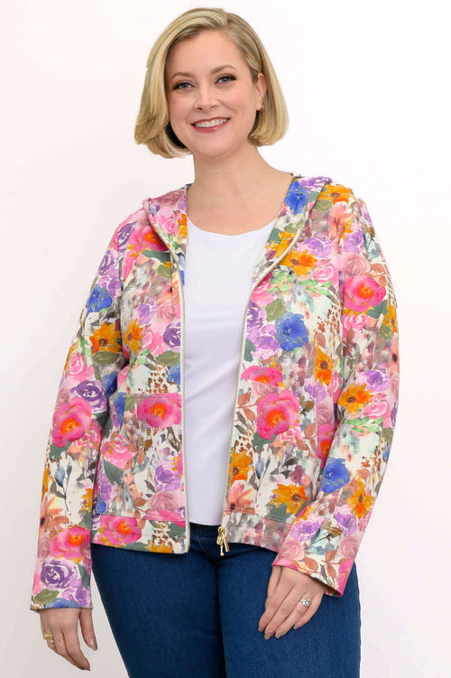 Woman wearing a vibrant pink floral zip-up jacket with hood, front view