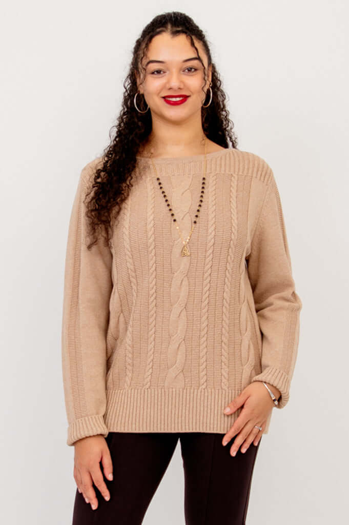Front view of woman wearing a beige cable knit sweater with boat neck