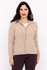 Woman wearing a beige zip-front hoodie with hood down, front view