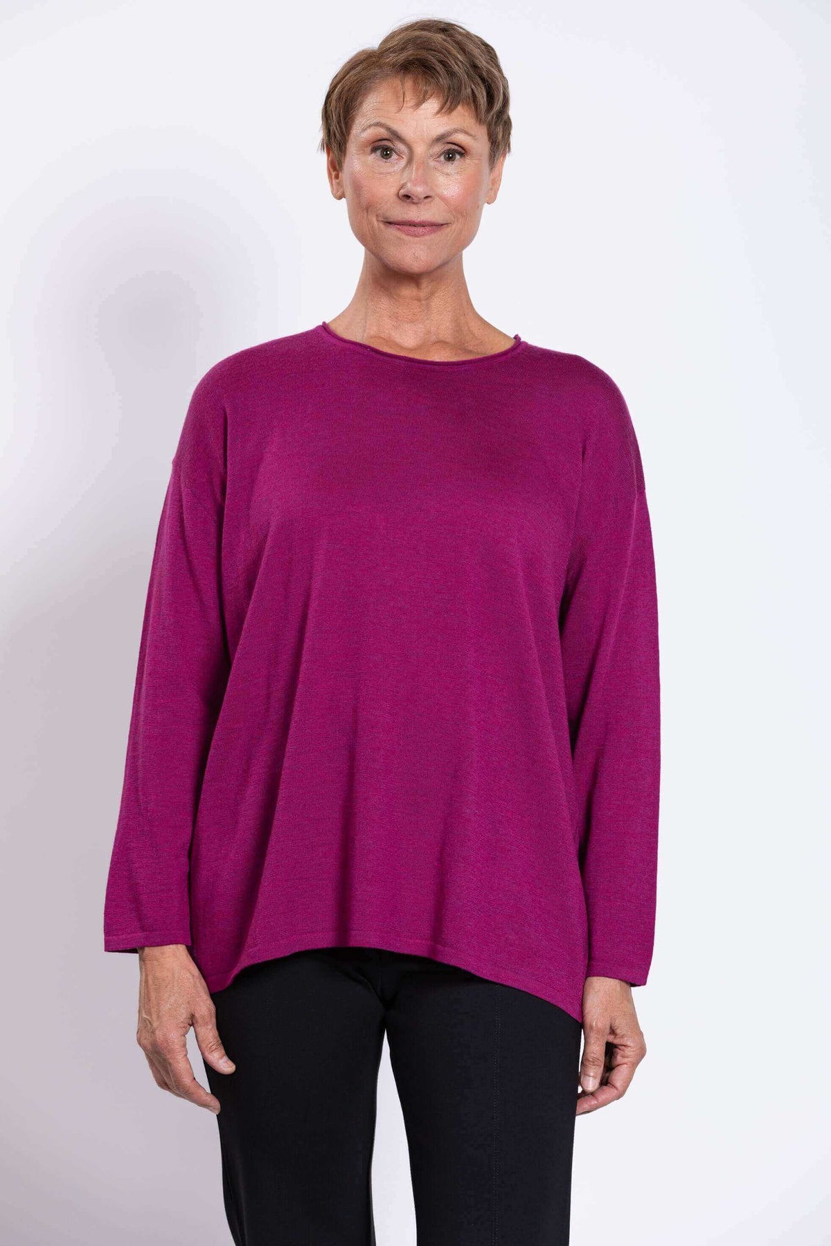 Front view of a woman wearing a vibrant berry Merino wool pullover sweater