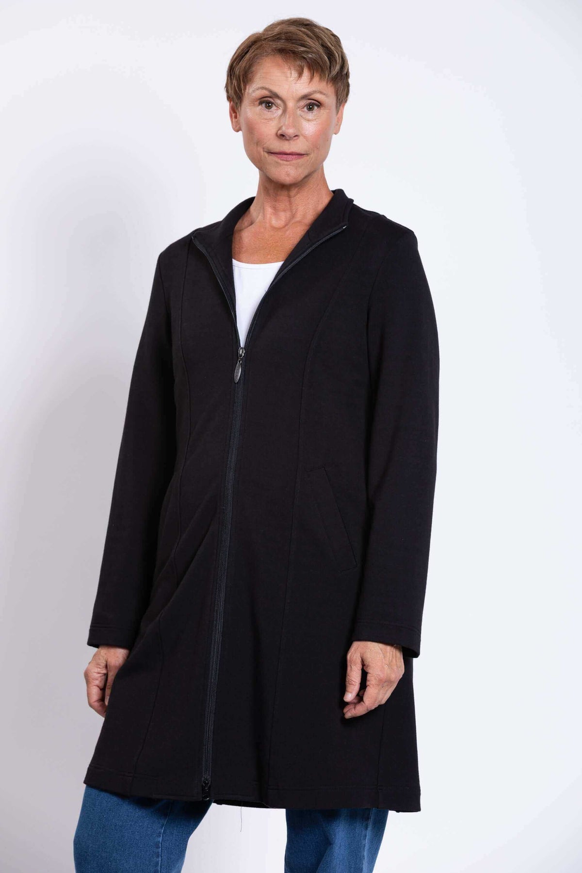 Front view of woman in black Tracy Coat with zipper and pockets