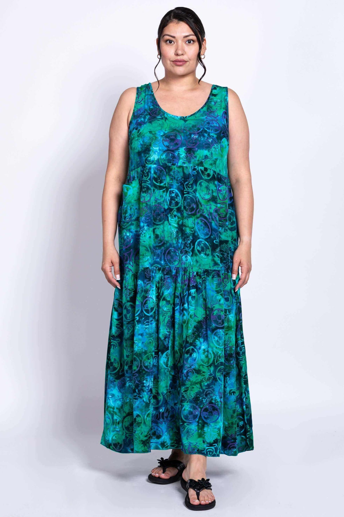 Woman wearing sleeveless blue and green tiered maxi dress, front view
