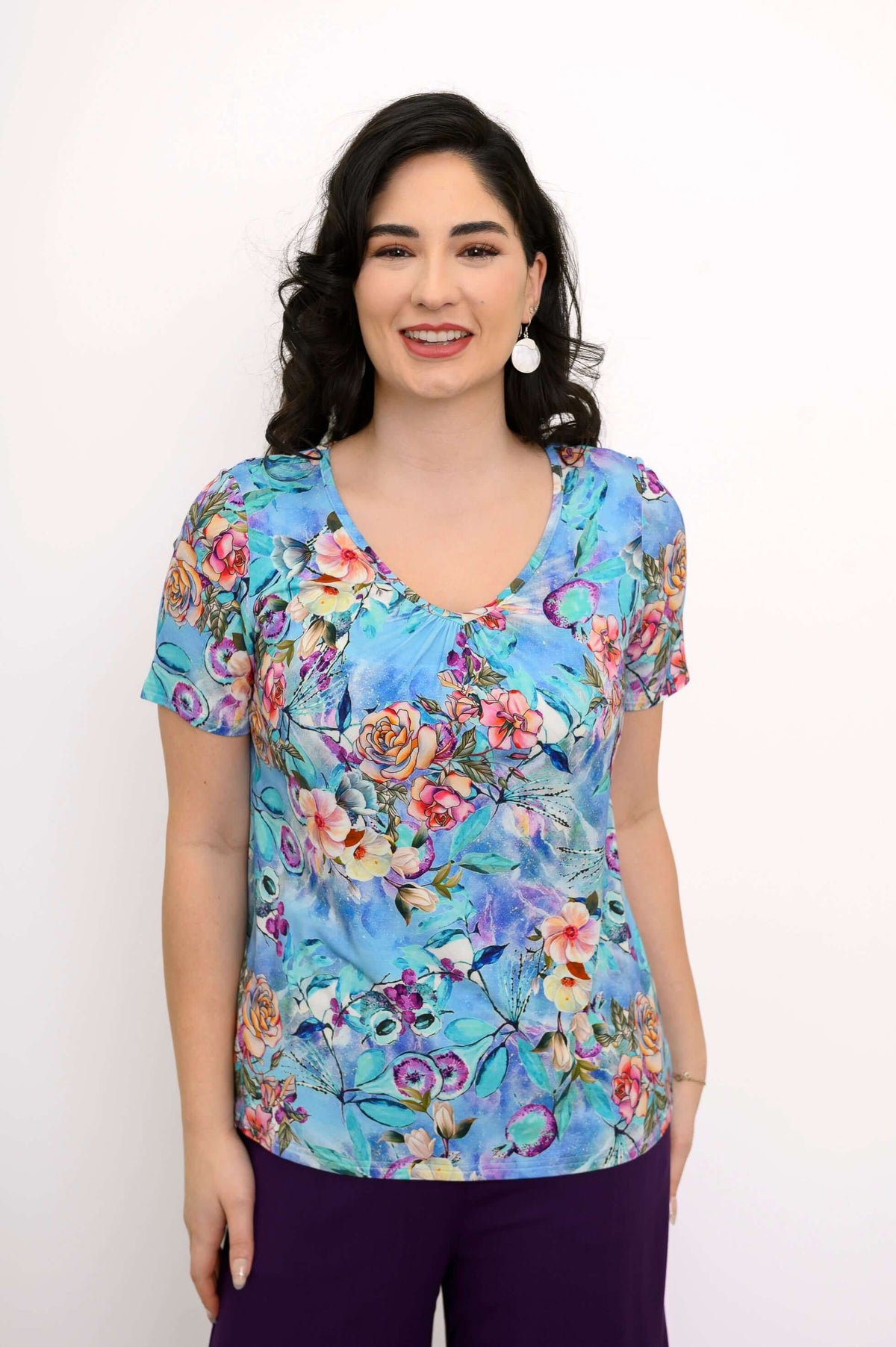 Front view of a woman wearing a short sleeve blue floral bamboo top