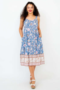 Front view of woman in a blue floral empire waist dress with pockets