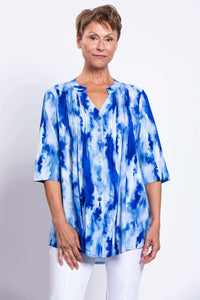 Front view of a woman wearing a blue tie-dye Margate blouse with mandarin collar and pintucks