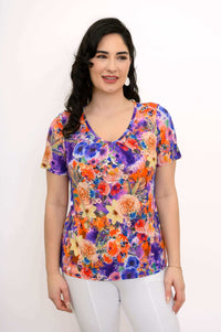 Woman wearing a colorful floral bamboo top with short sleeves, front view
