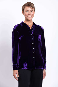Woman wearing a deep purple silk velvet blouse, front view, smiling