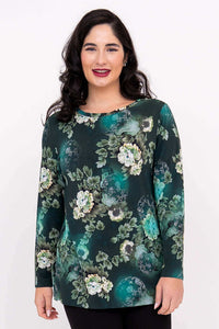 Woman wearing a long sleeve green floral boat neck top, front view