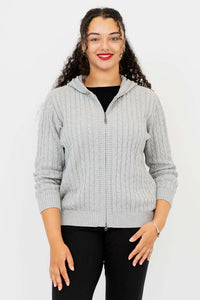 Front view of woman modeling a light grey cable knit zip-up sweater with hood