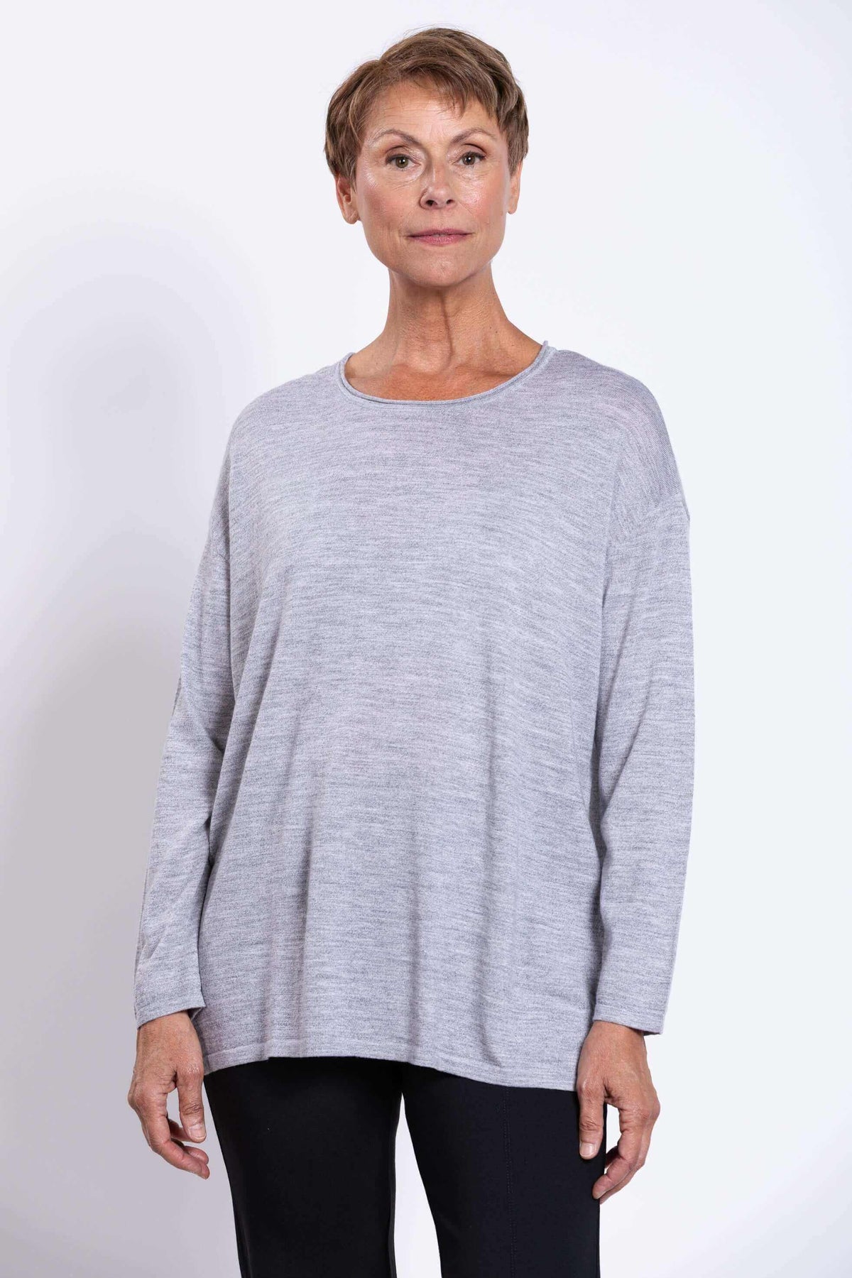 Front view of woman wearing a light grey long sleeve merino pullover sweater