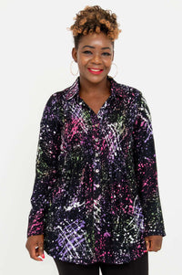 Front view of a woman wearing a long sleeve buttoned tunic with a vibrant abstract print