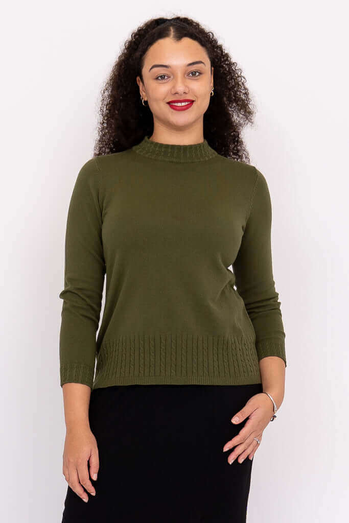 Front view of a woman wearing an olive green mock neck sweater