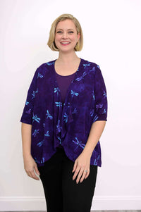 Woman wearing a purple Toucan Jacket with blue dragonfly print, smiling front view