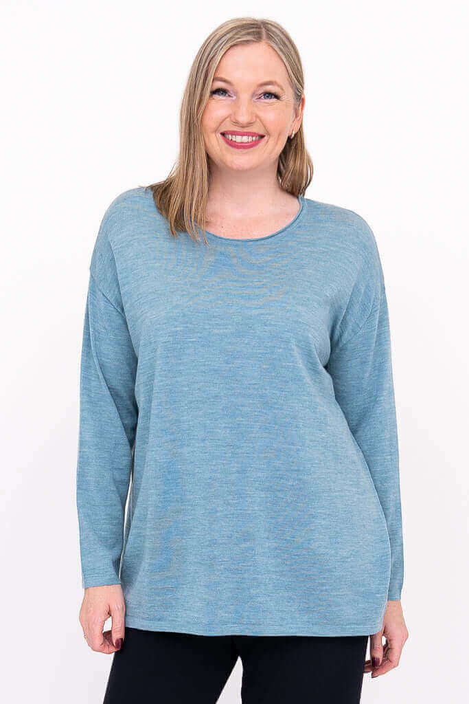 Woman wearing a relaxed fit light blue Merino wool sweater, front view
