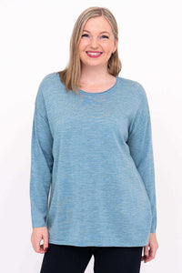 Woman wearing a relaxed fit light blue Merino wool sweater, front view