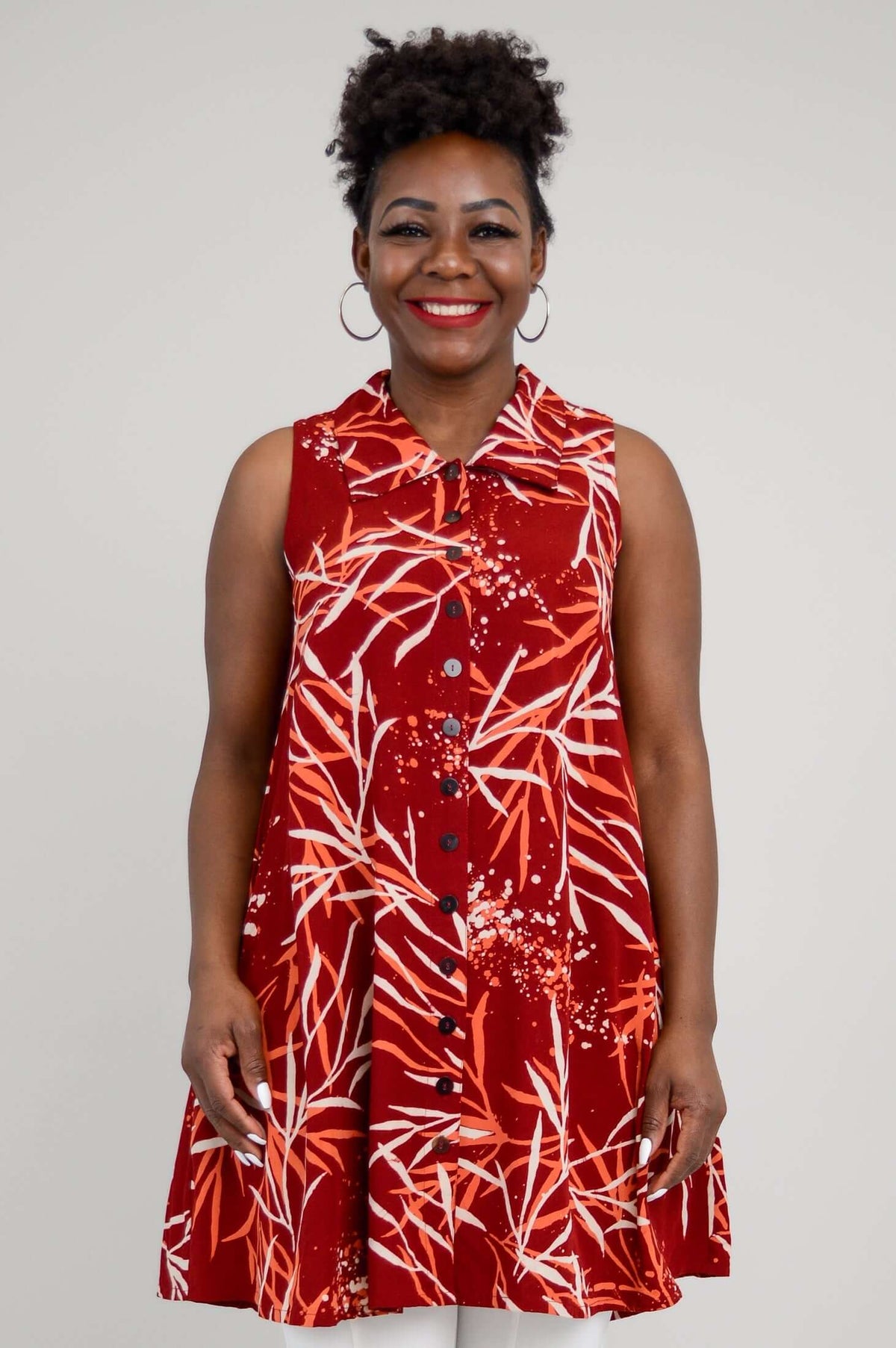 Front view of a woman wearing a sleeveless red A-line tank top with a bamboo print