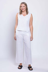 Front view of woman wearing white wide-leg striped pants and matching sleeveless top
