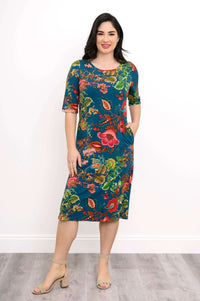 Woman wearing a teal bamboo dress with vibrant floral pattern, front view